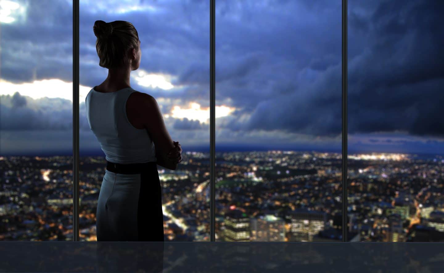 woman looking over city at night