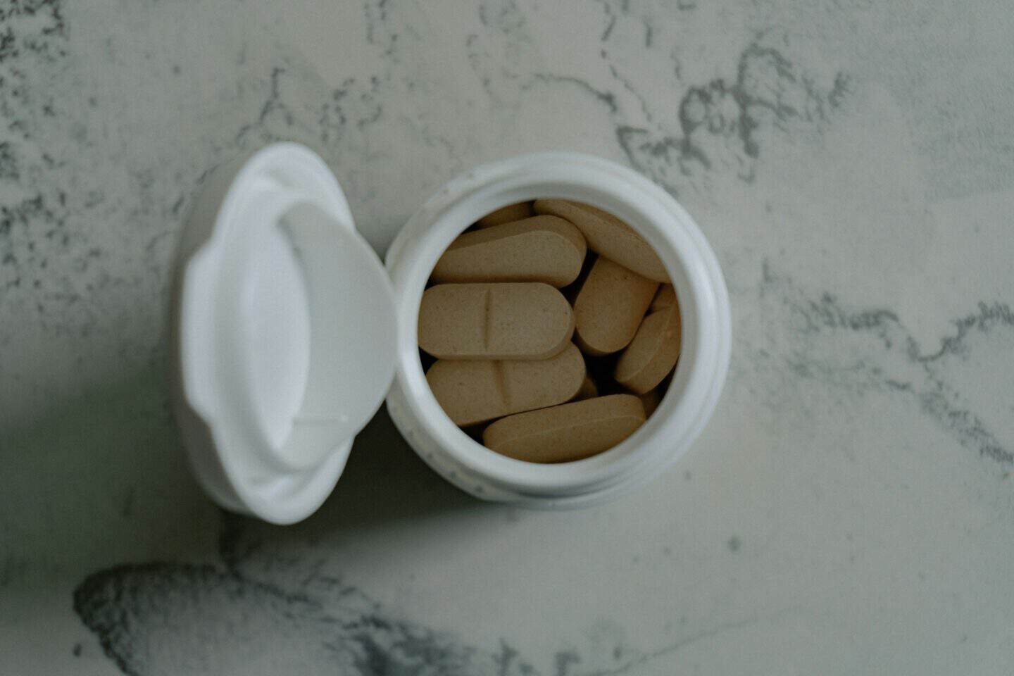 Assorted vitamin capsules and supplement bottles on a counter - What Makes a Quality Supplement: A Parent Guide