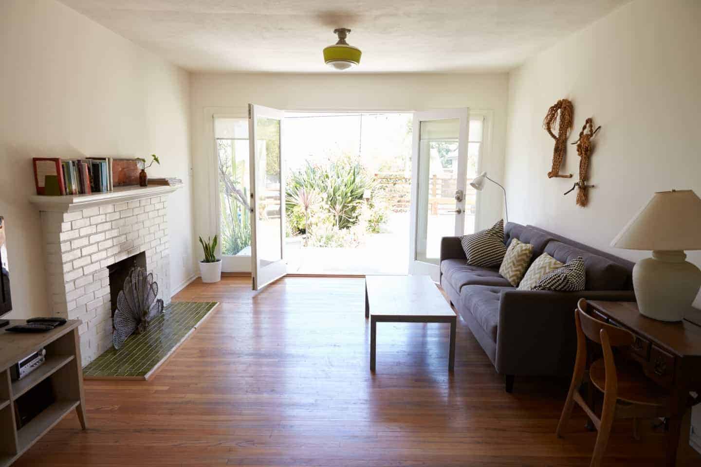 A living room filled with furniture and a fire place with door wide open