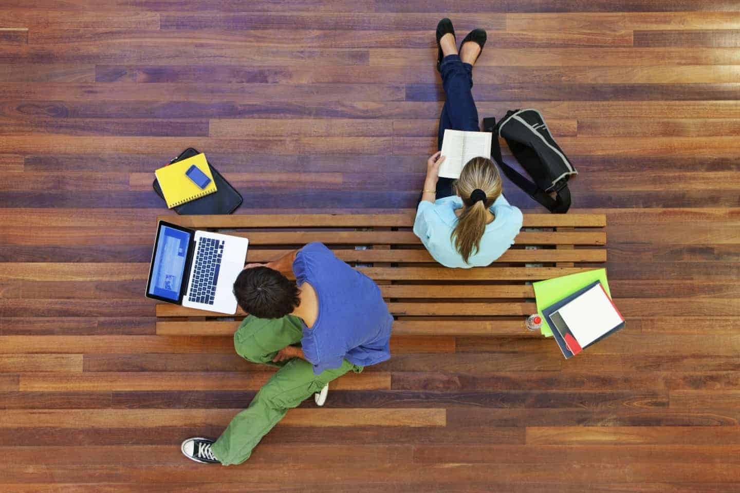 students working and reading on a bench