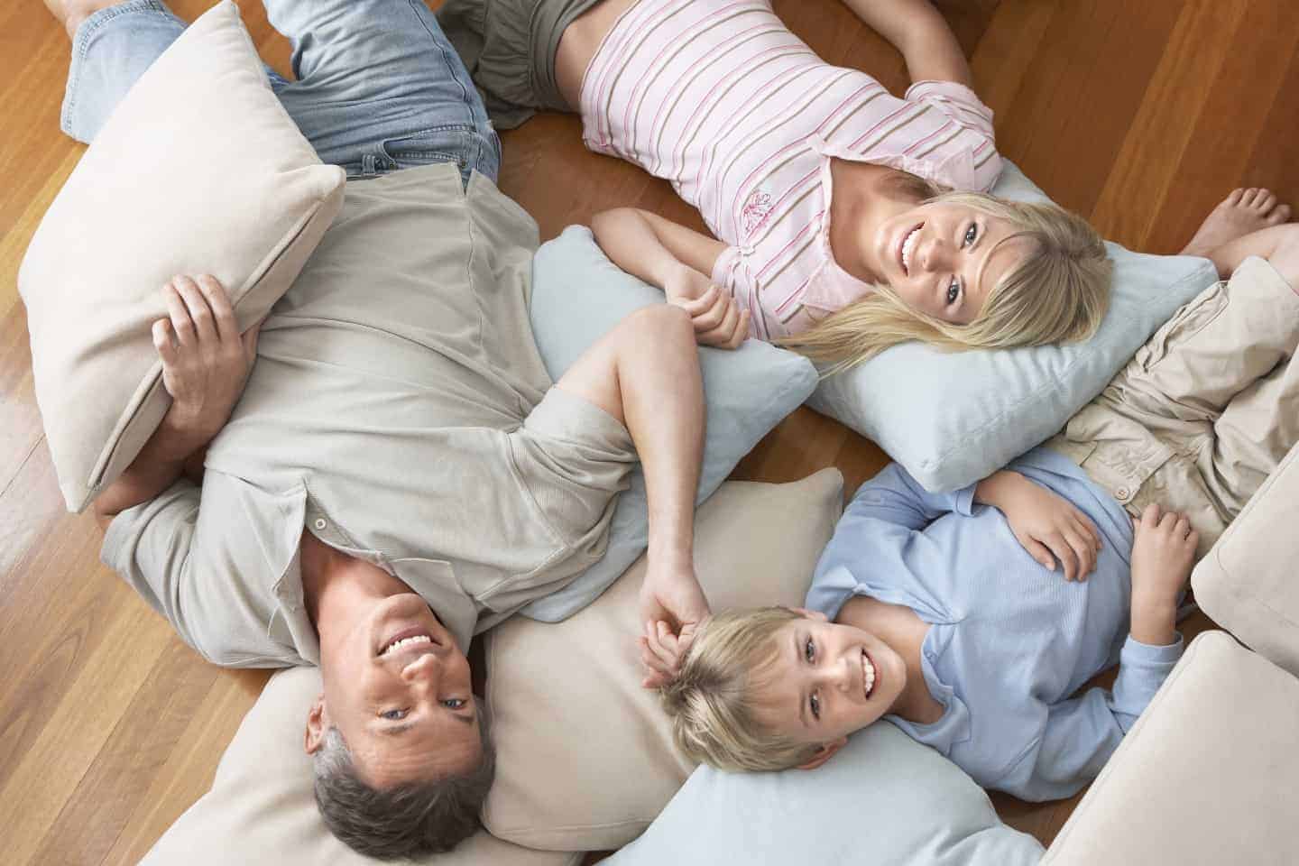 father with children lying on the floor smiling