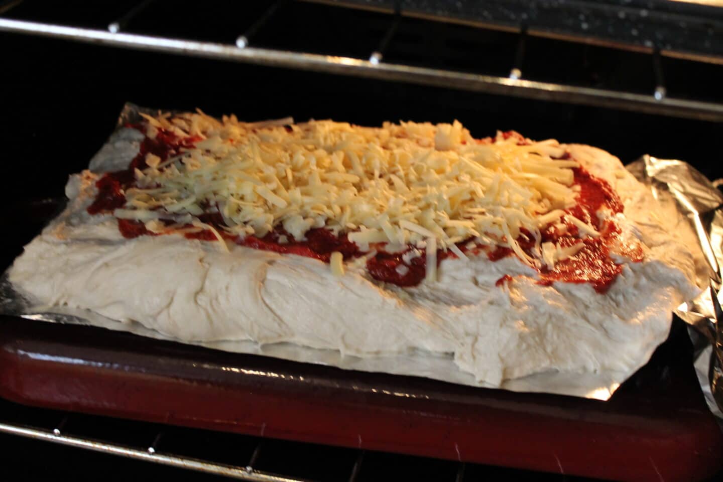 Pizza dough with tomato and cheese on top in the oven