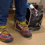 man`s legs with blue trousers and colorful sneakers with untied shoelaces