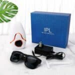 IPL hair removal device with laser technology for permanent hair reduction at home. Includes sunglasses for protection, power adapter, and razor for pre-treatment grooming.