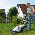 Man mowing lawn in backyard