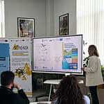 Prezentacja podczas PHD RISK Summer School, wykład na temat zarządzania ryzykiem i analizy danych, uczestnicy słuchają uważnie w nowoczesnym wnętrzu konferencyjnym.