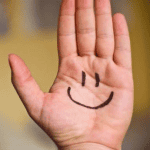 Negatieve eigenschappen positief ombuigen, tijdens de oefening glimlach je erom. Op deze hand staat een smile getekend met zwarte stift inkt