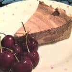 Coffee and chocolate cheesecake served with fresh cherries