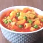 Pasta soup with small pasta tubes, peas and a tomato sauce.