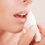 Woman applying homemade lip balm on her lips