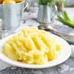 White plate of mashed potatoes on the grey background