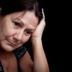 An image of an middle aged woman who is sad