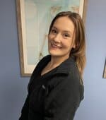 a woman smiling in front of a painting