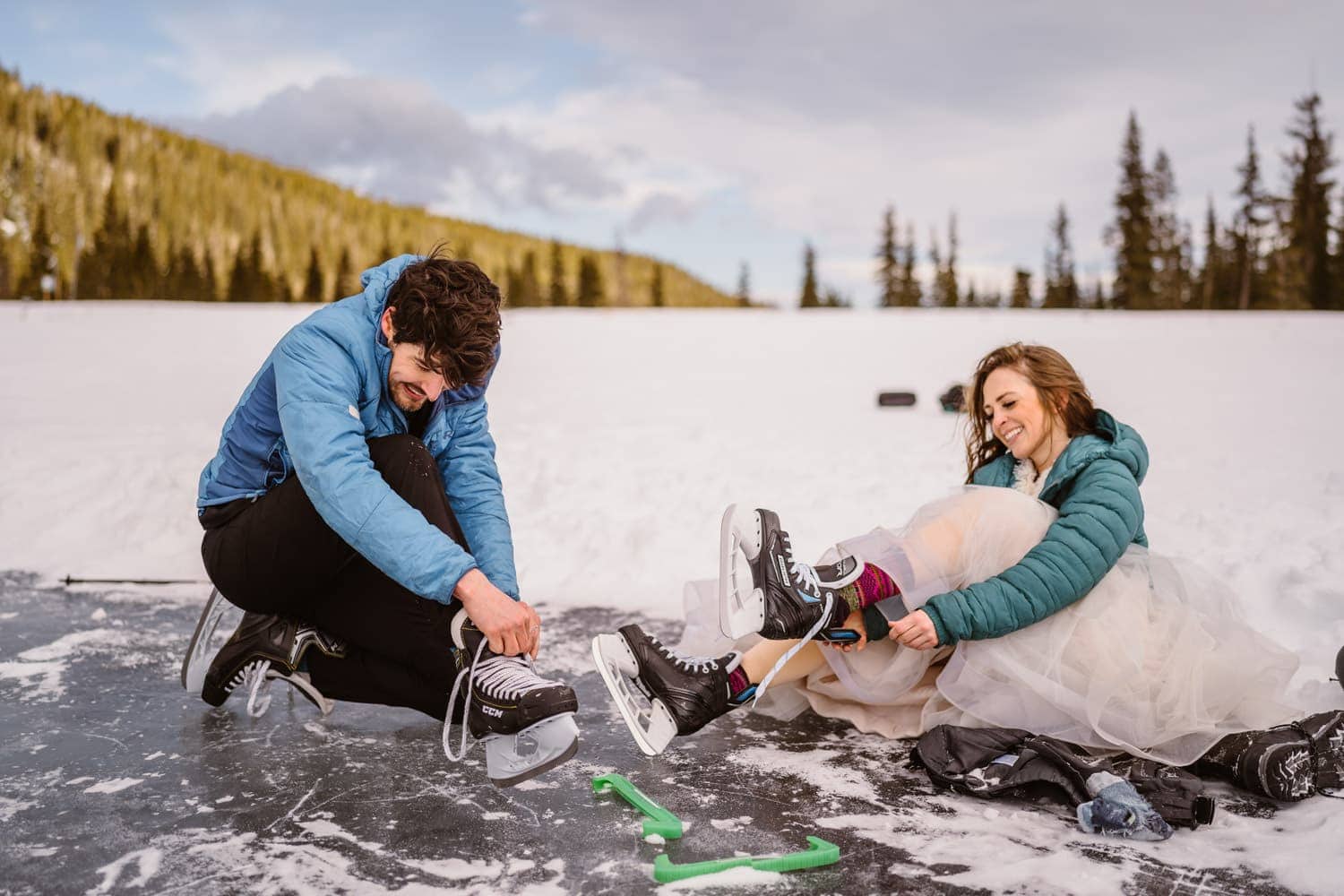 Bride and groom lacing up their ice skates on their wedding day