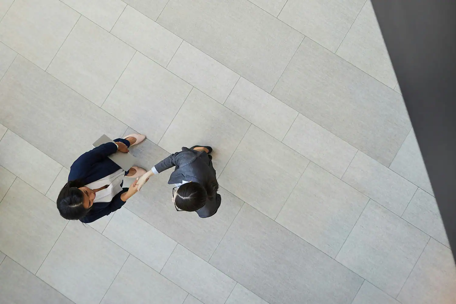 Trust: two people shaking hands in a corporate environment
