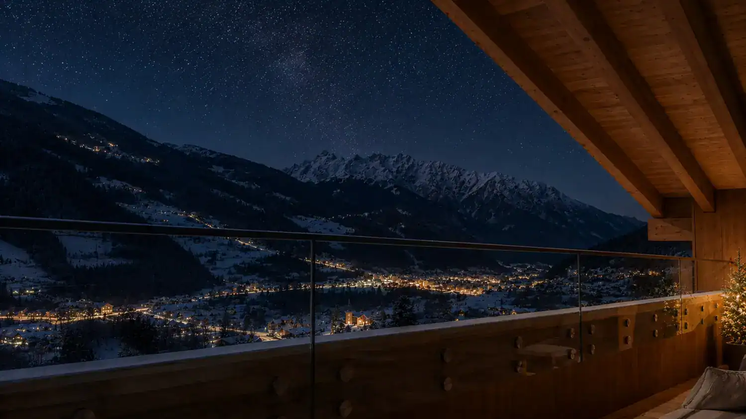 Nächtlicher Ausblick vom Balkon der Silvretta Panorama Suites auf ein romantisch beleuchtetes, tief verschneites Tal unter einem klaren Sternenhimmel.