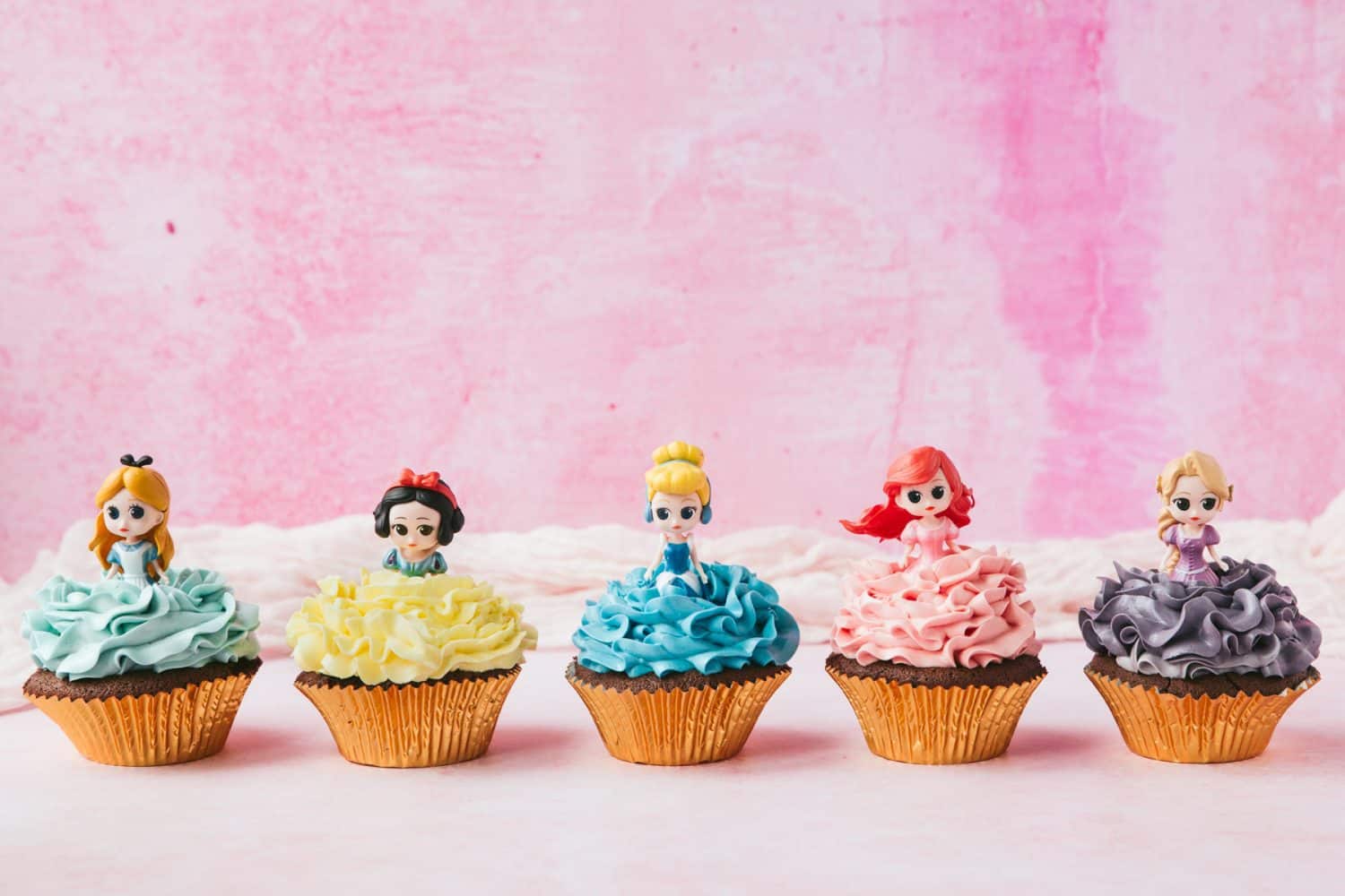 How To Make Princess Cupcakes | Coral's Blog - Food Blog - Cooking Guide 1 A row of Disney Princess Cupcakes. Alice in Wonderland, Snow White, Cinderella, Ariel and Rapunzel with coloured frosting.