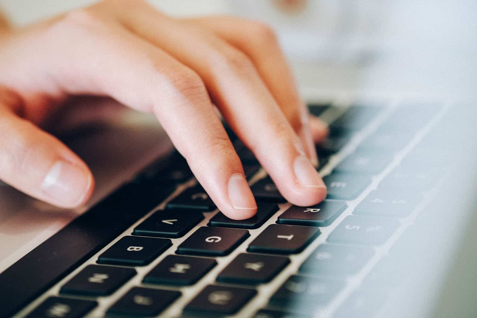 Closeup of a person typing on a laptop keyboard