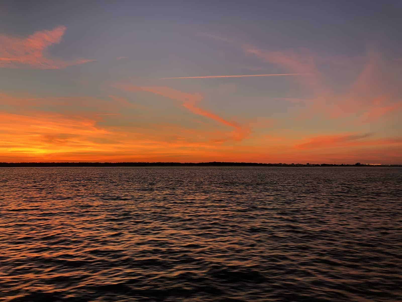 Orange sunset on the water. Sunset dolphin cruise Charleston, SC