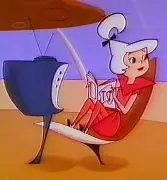 Judy Jetson smiling in a futuristic living room, holding a space-age phone.
