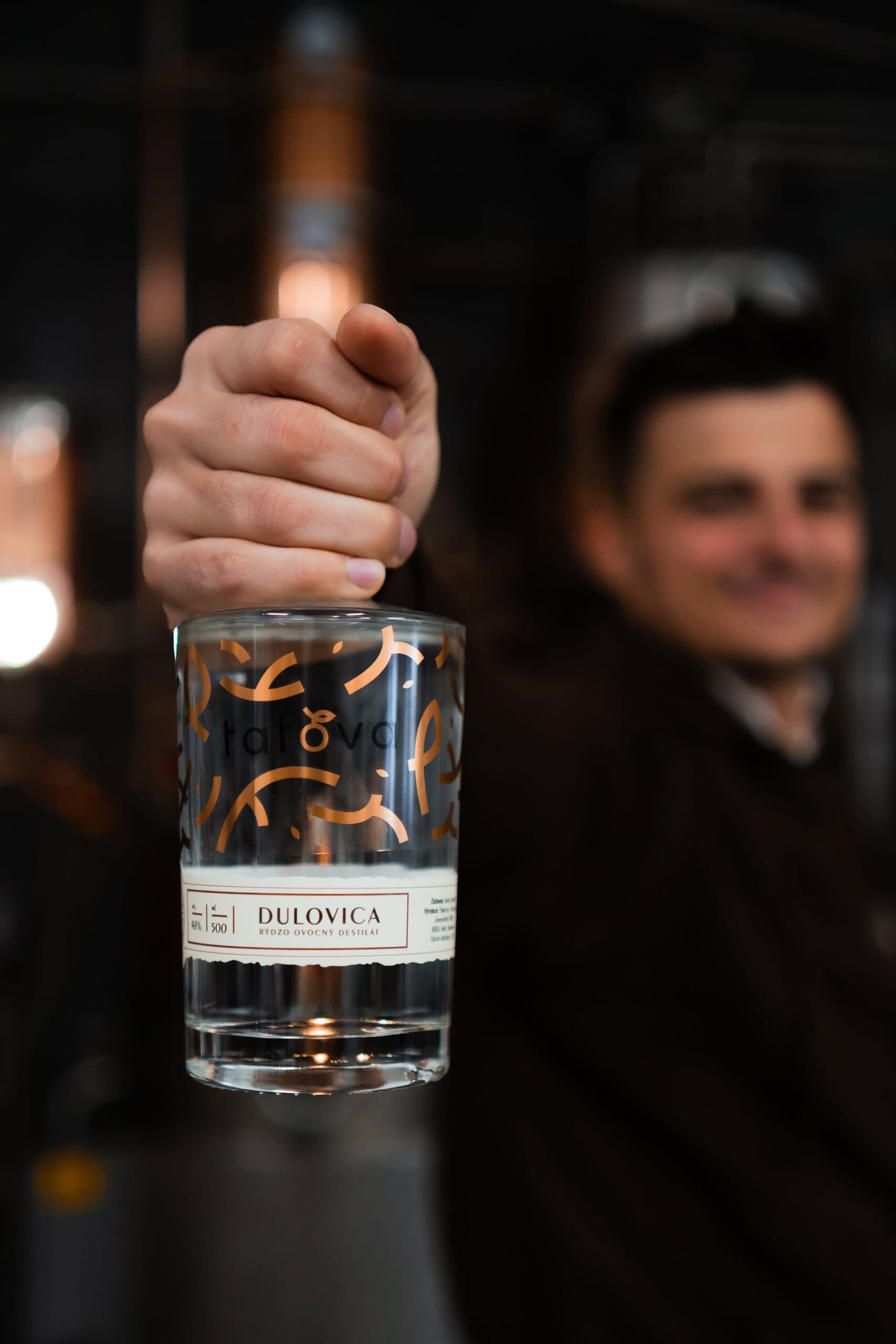 barman drziaci lahev dulovice tatova z lokalnych dul s obsahom alkoholu 48%, objem 0,5L