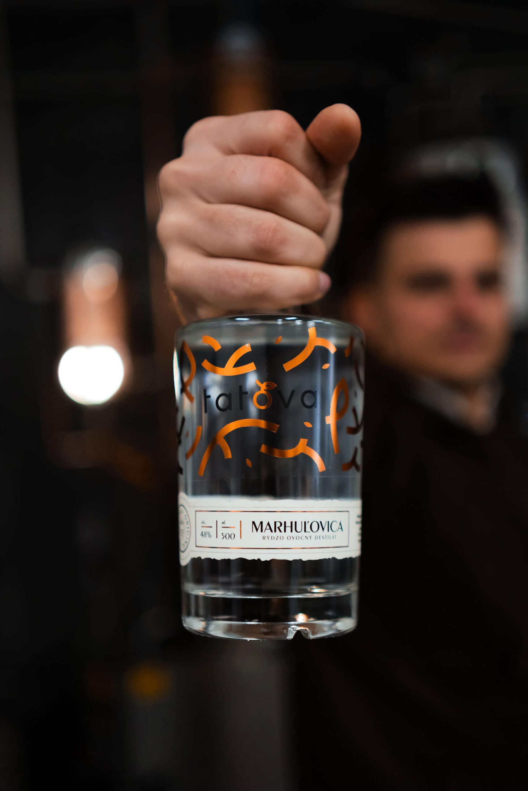 barman drziaci lahev marhulovice tatova z lokalnych marhul s obsahom alkoholu 48%, objem 0,5L