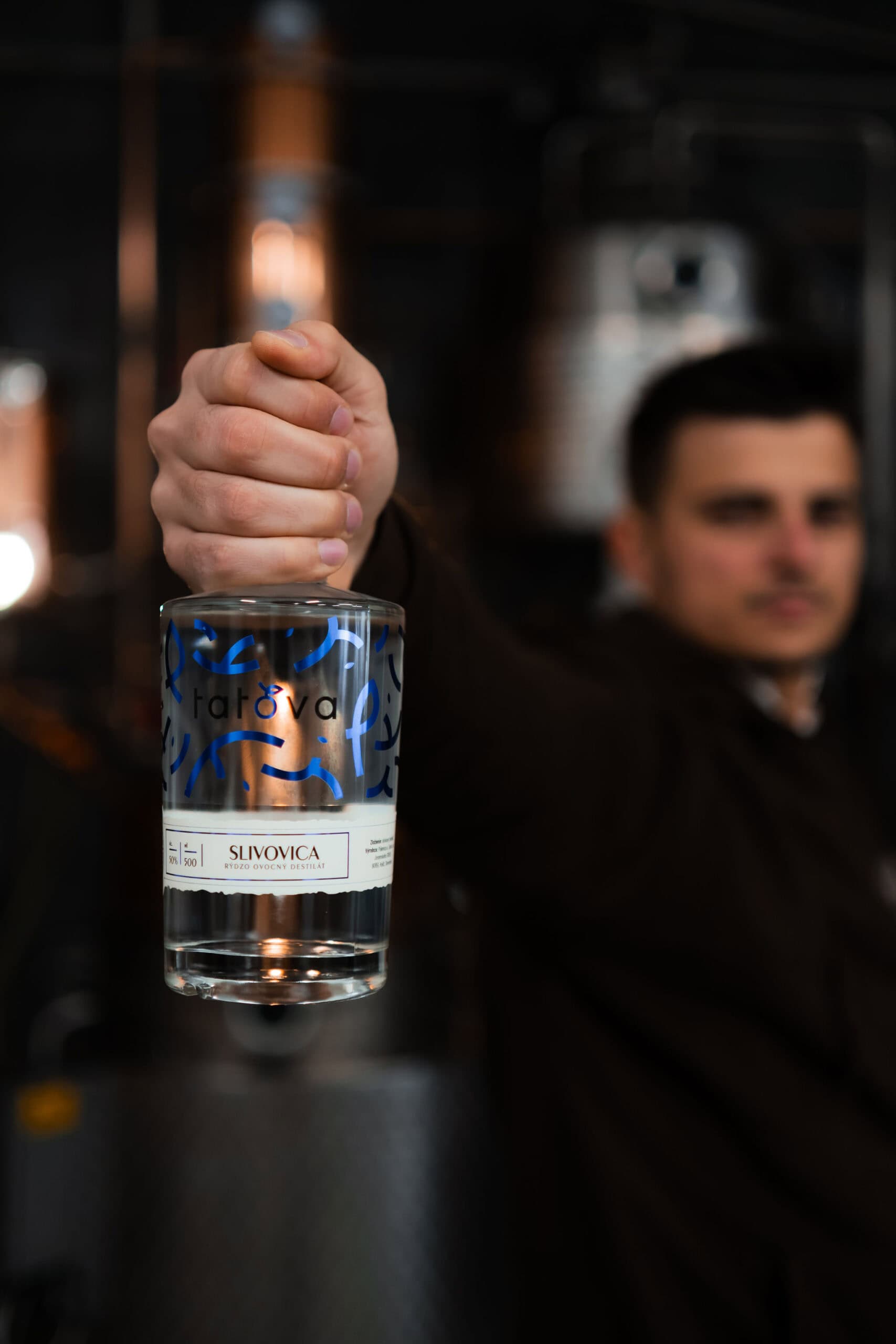 barman drziaci lahev slivovice tatova z lokalnych sliviek s obsahom alkoholu 50%, objem 0,5L