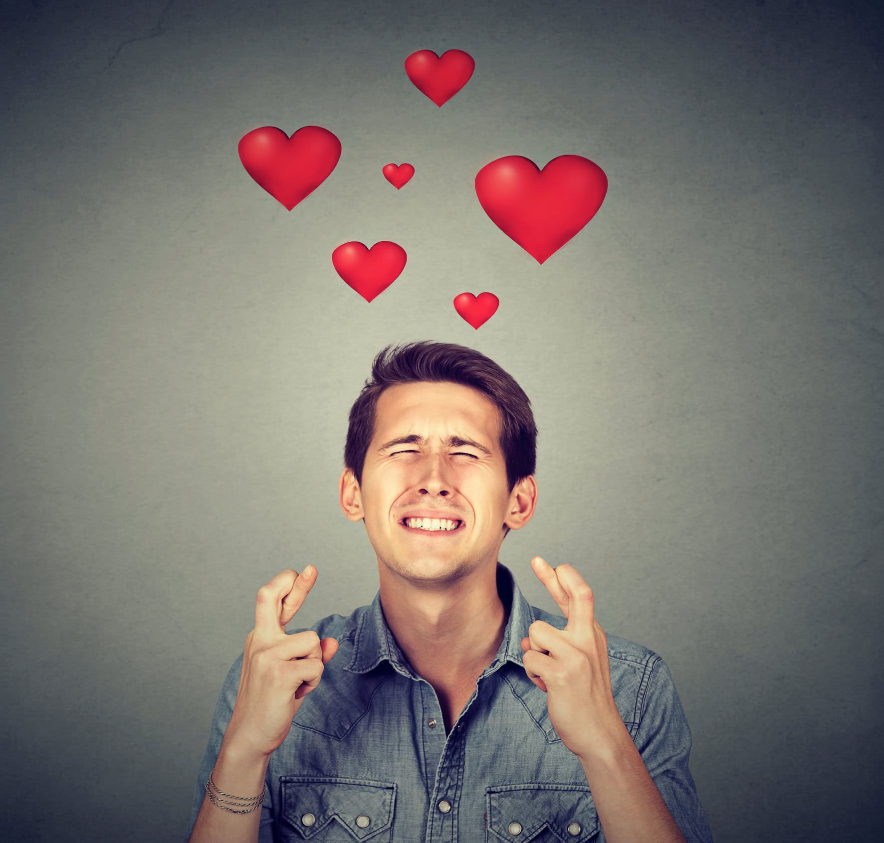 Man dreaming of his true love and crossing his fingers.