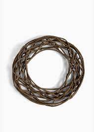 A circular wreath made of intertwined dark brown twigs.