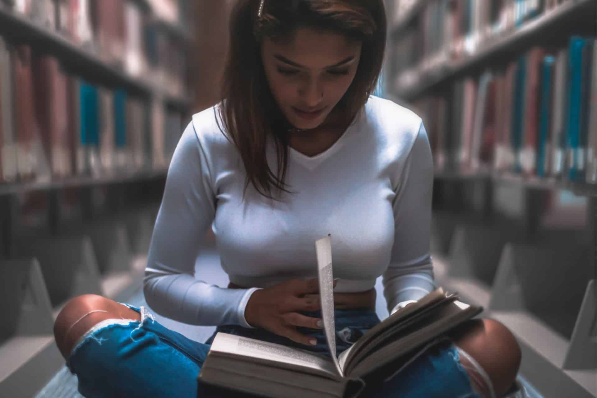 A woman decoding text in a library.