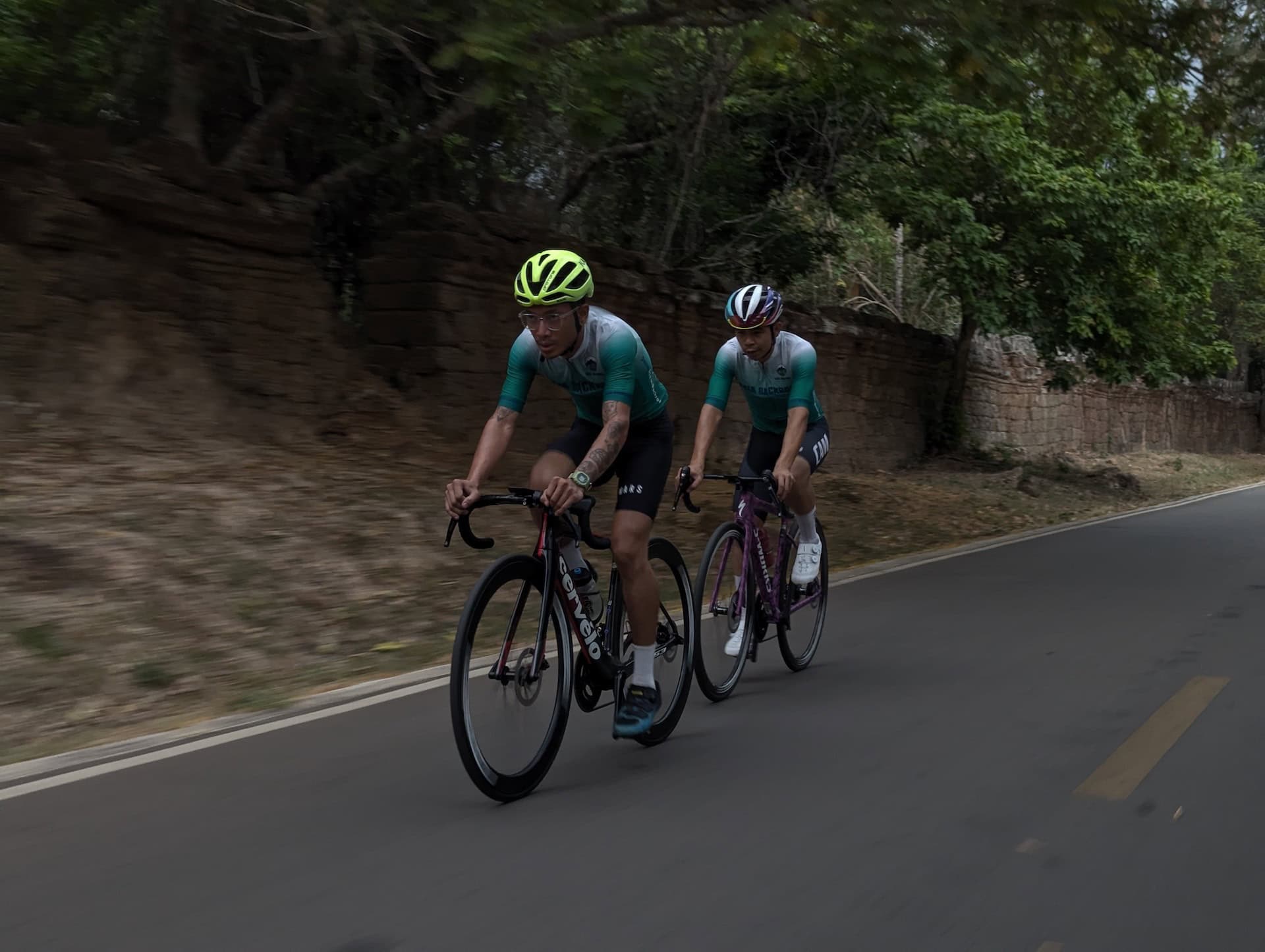 Cyclists riding through the scenic Cambodian countryside on a guided Cambodia road bike tour from Angkor Wat to the southern coast.