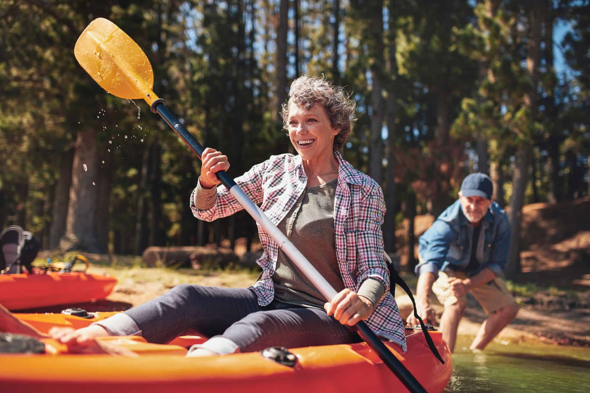 A mature woman and her date kayaking on a river as they find lasting love through embracing their shared life goals.