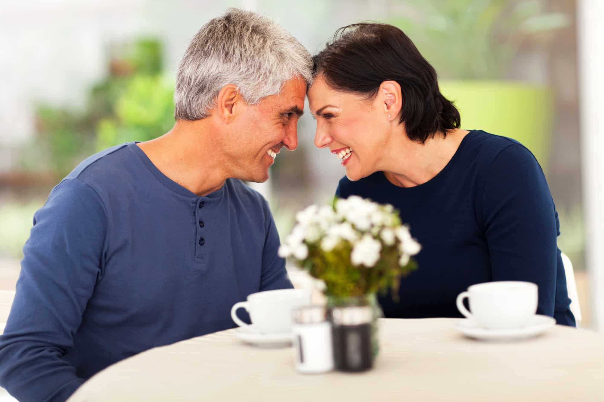 A happy, middle-aged couple is looking into each other's eyes while building trust in their relationship.