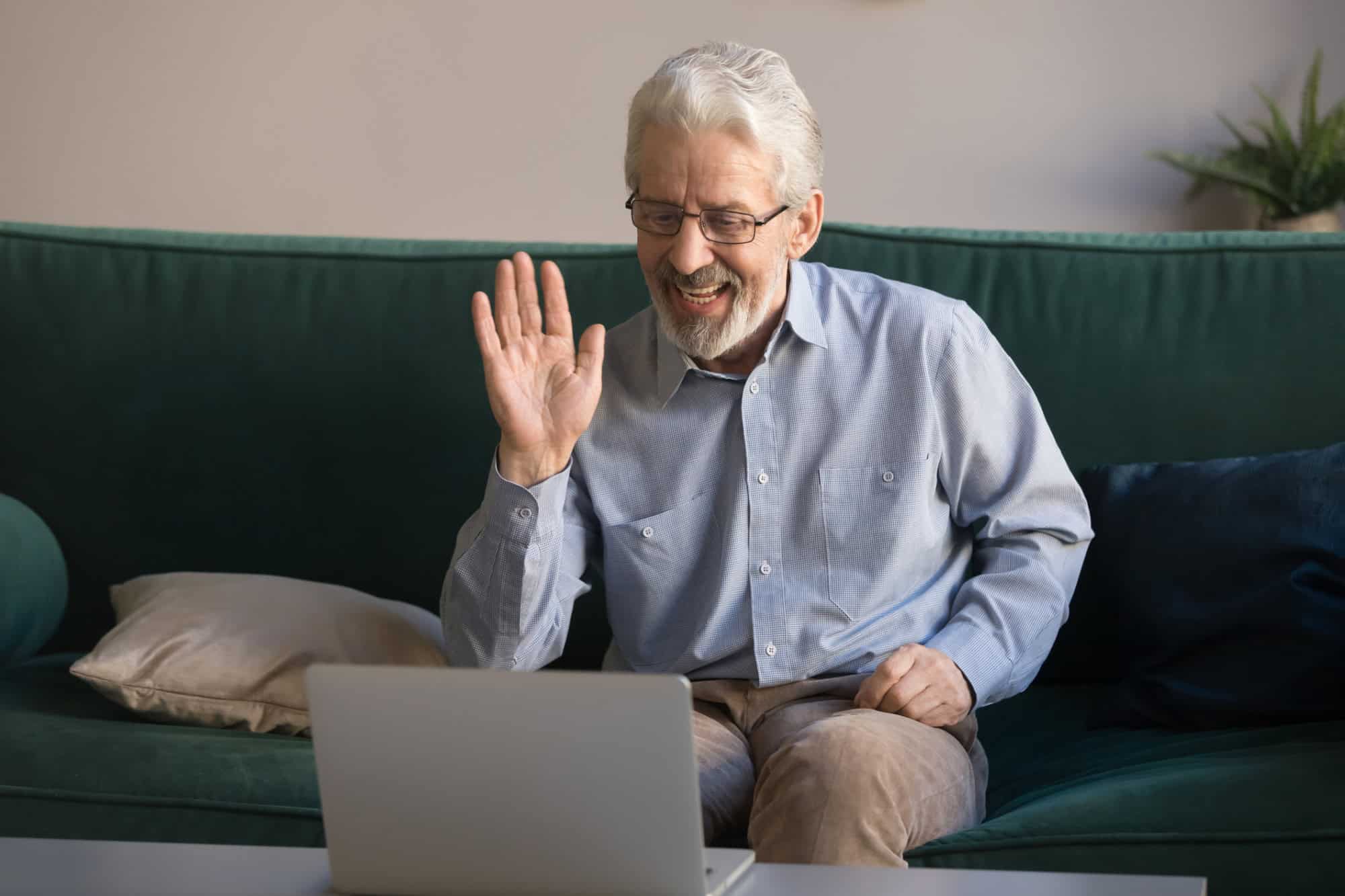 Divorced man sitting on his couch greeting his online date.