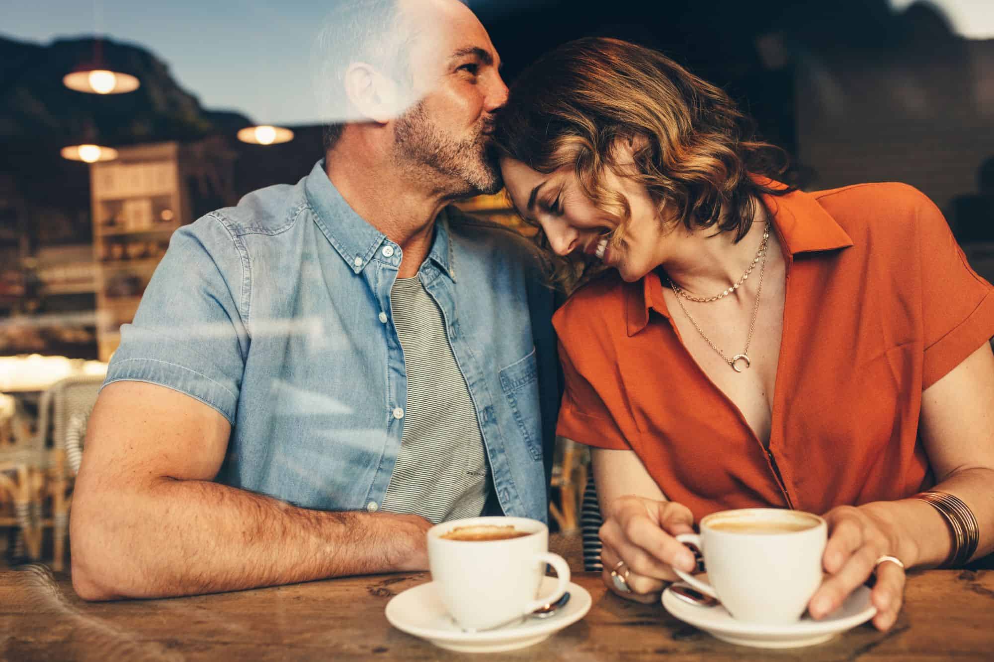 Happy couple being more romantic on a coffee date in a cafe.