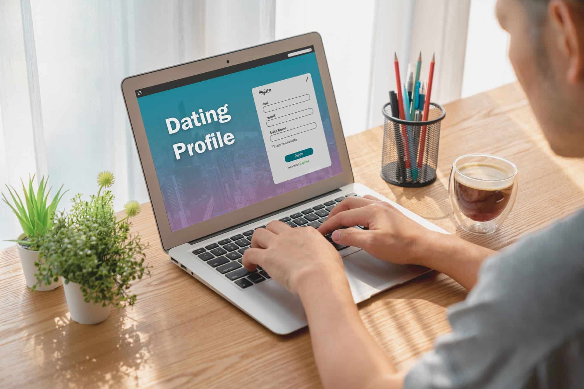 A man filling out an online dating profile on his laptop and preparing to share his why for dating.