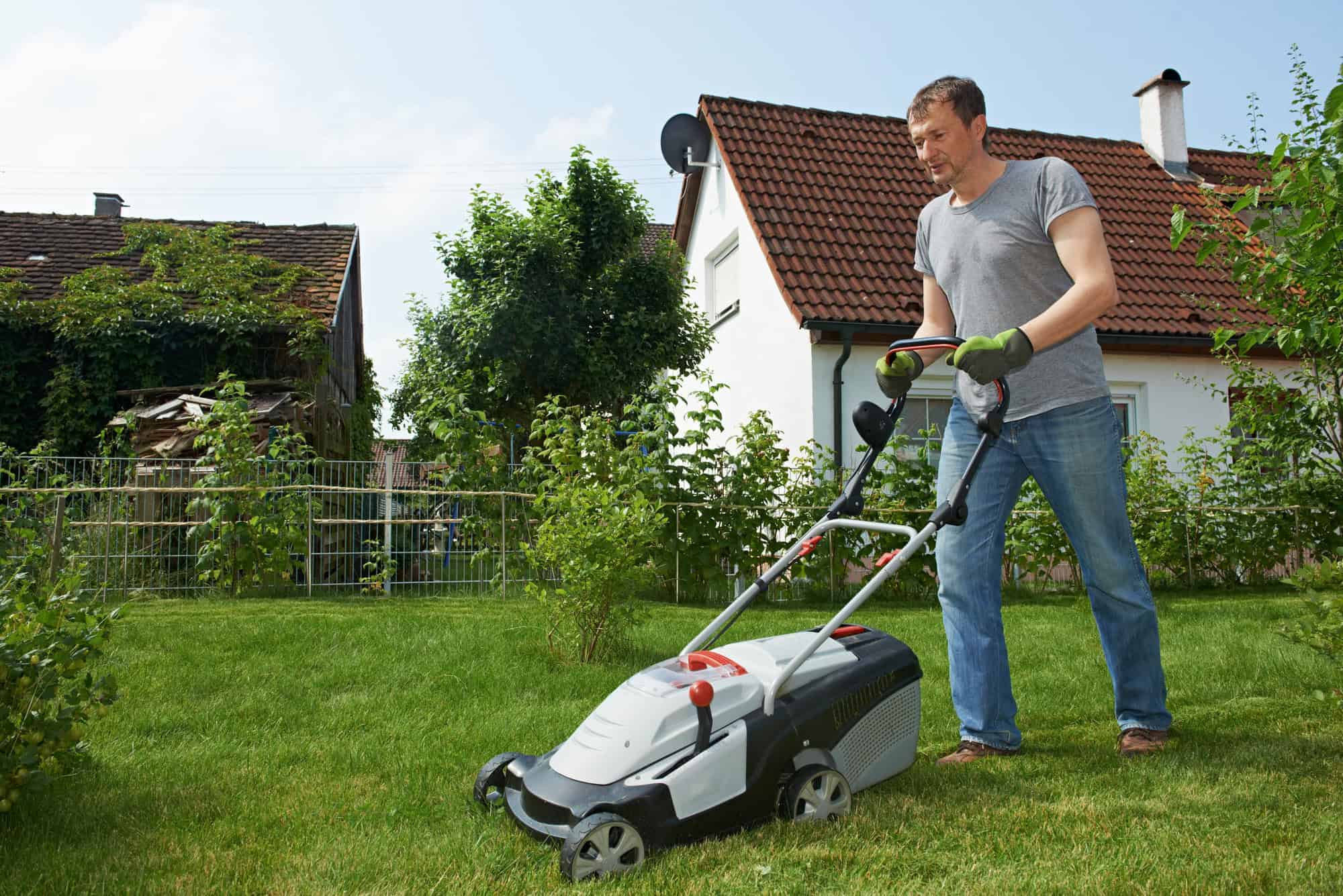 Man mowing lawn in backyard
