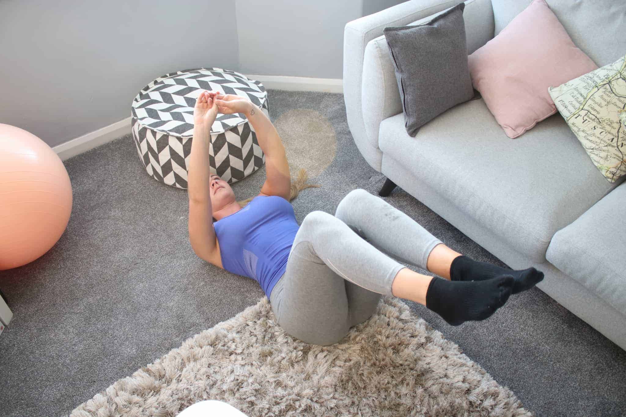 Woman exercising in her living room on rug