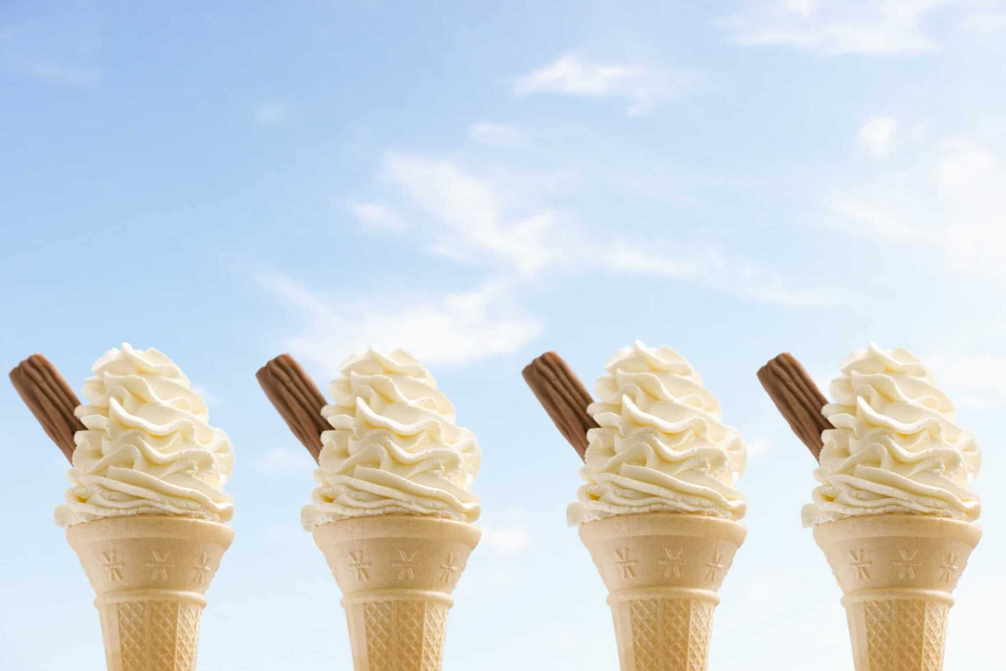 four ice creams with bright blue sky in the background