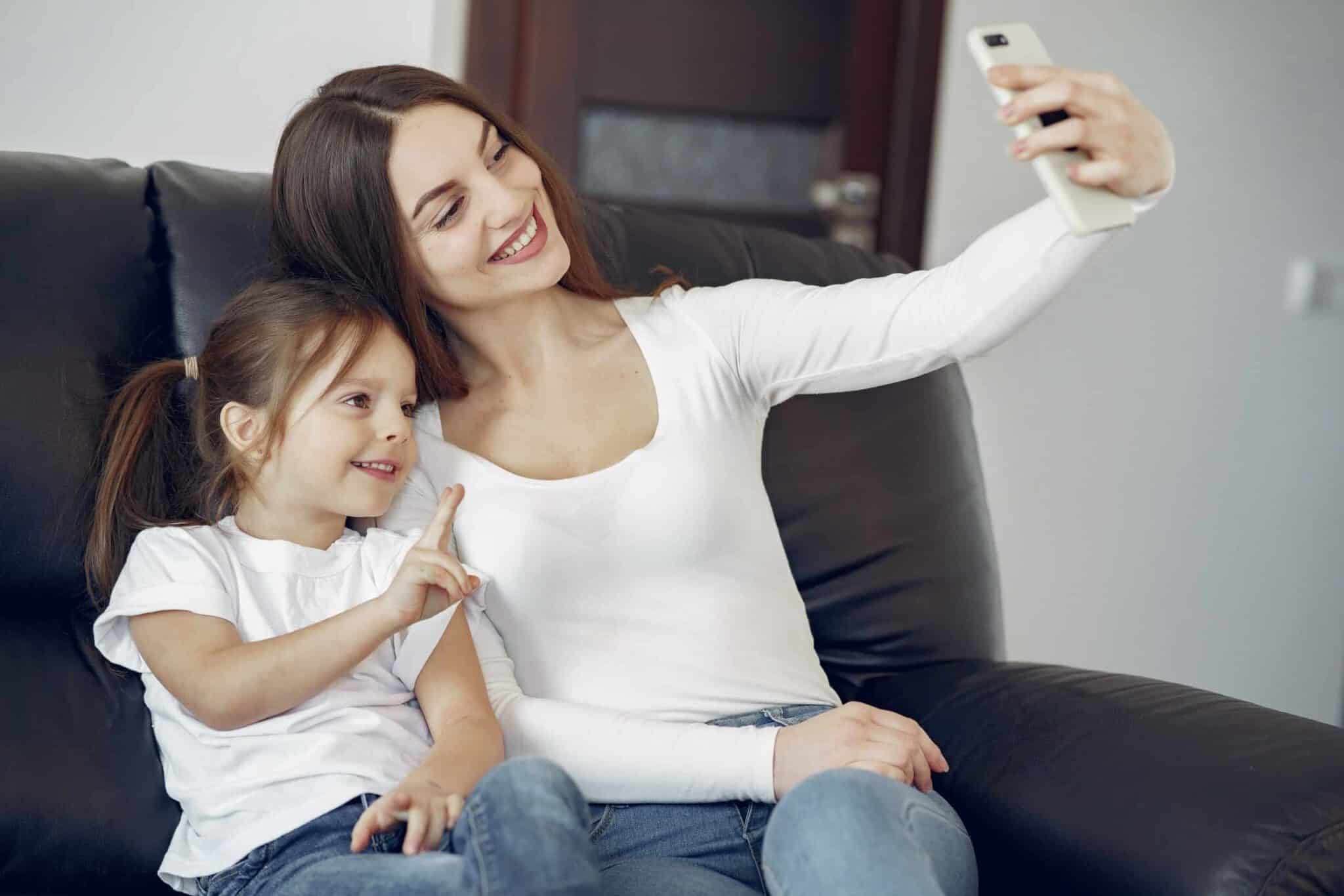Smiling mother and daughter taking a selfie