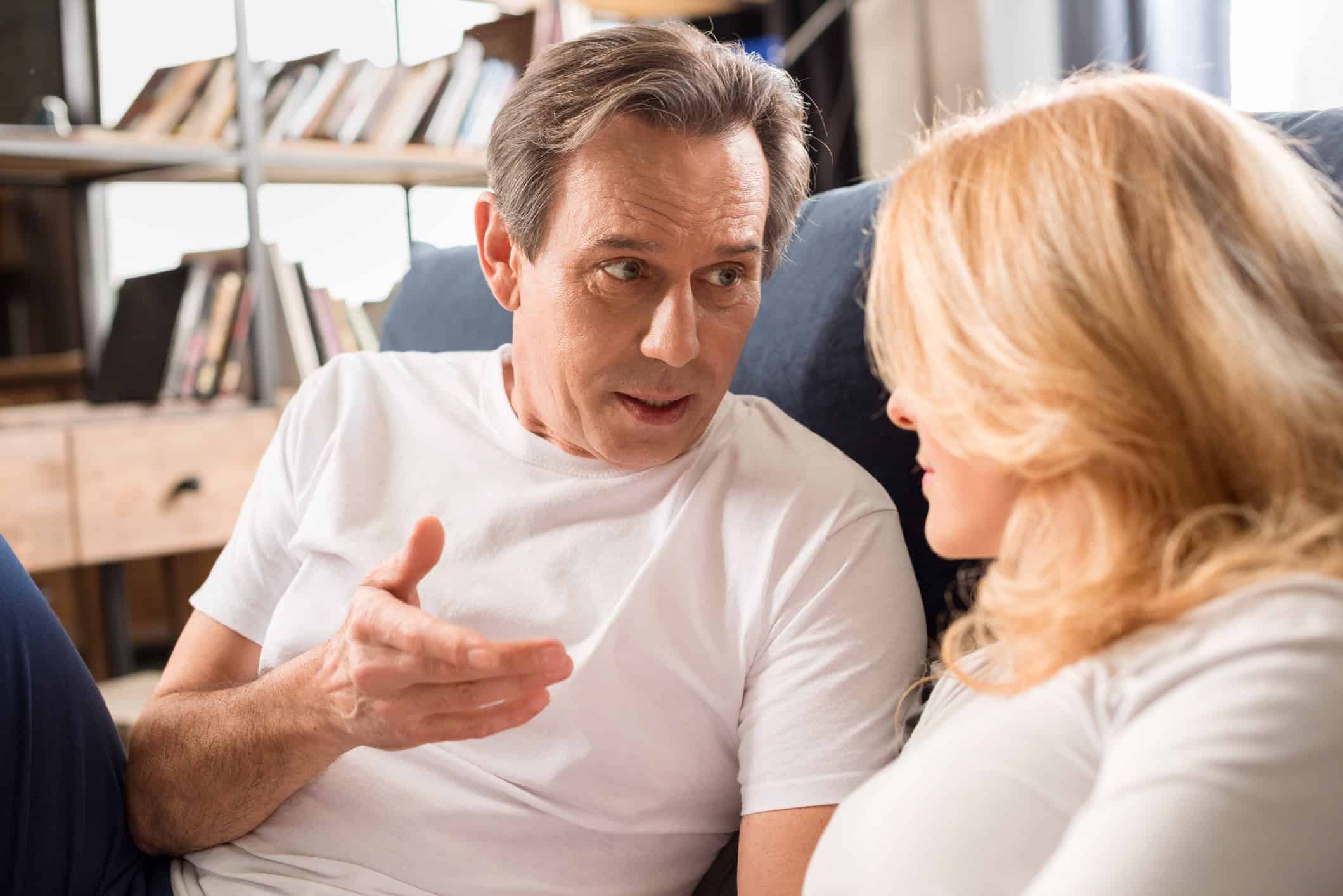 Couple sitting together on a couch and talking about relationship-building strategies.