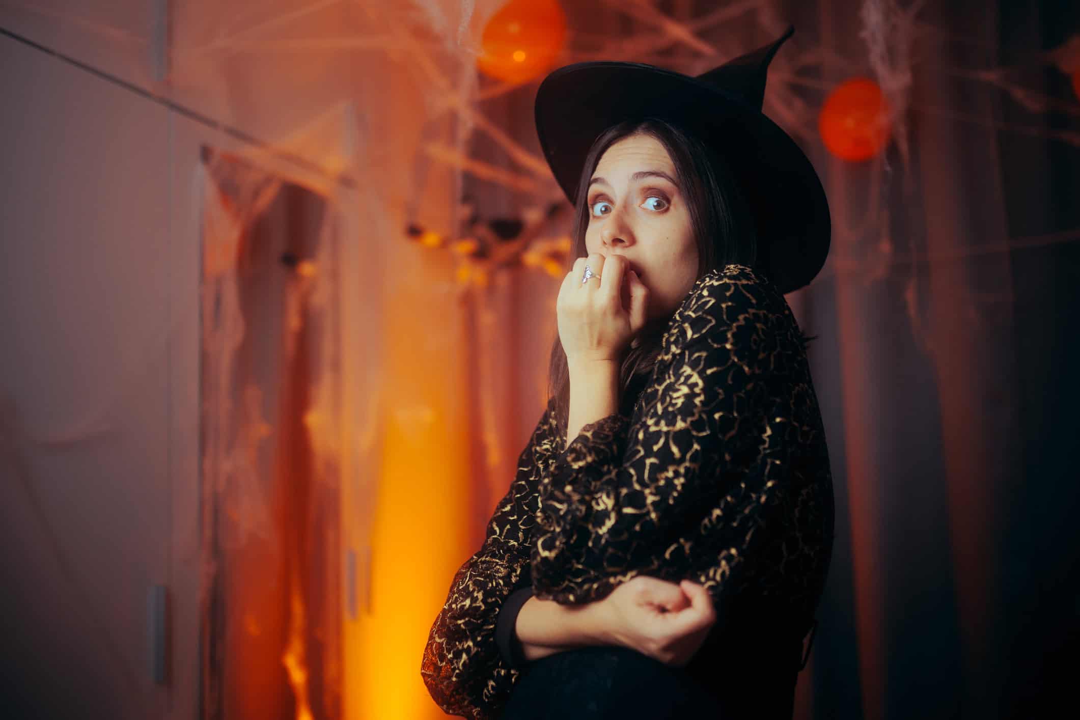 Woman who is scared of love dressed in a witch costume at a Halloween Party.