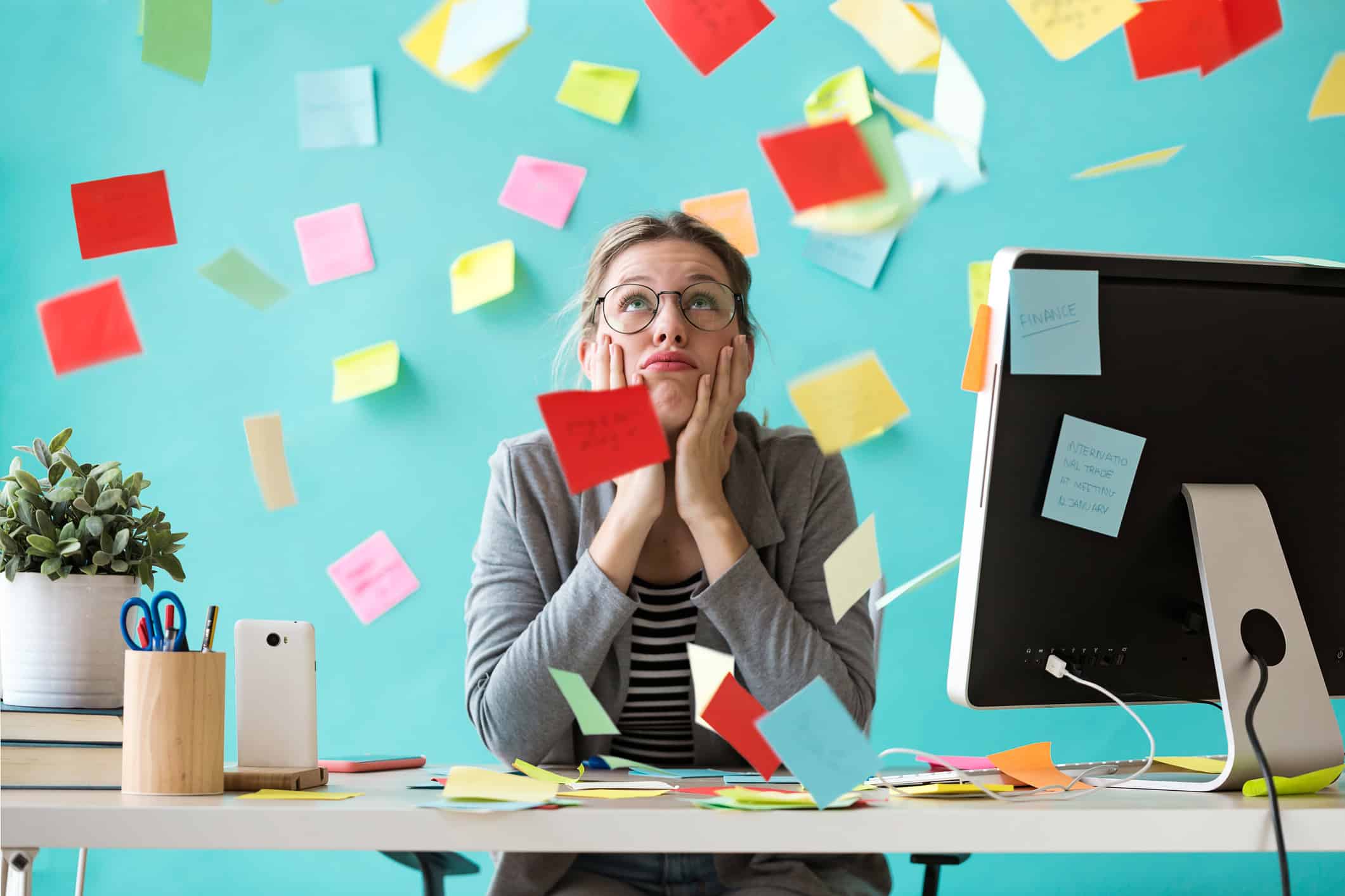 A young woman surrounded by sticky notes, looks frustrated as she realizes she is too busy for a relationship.