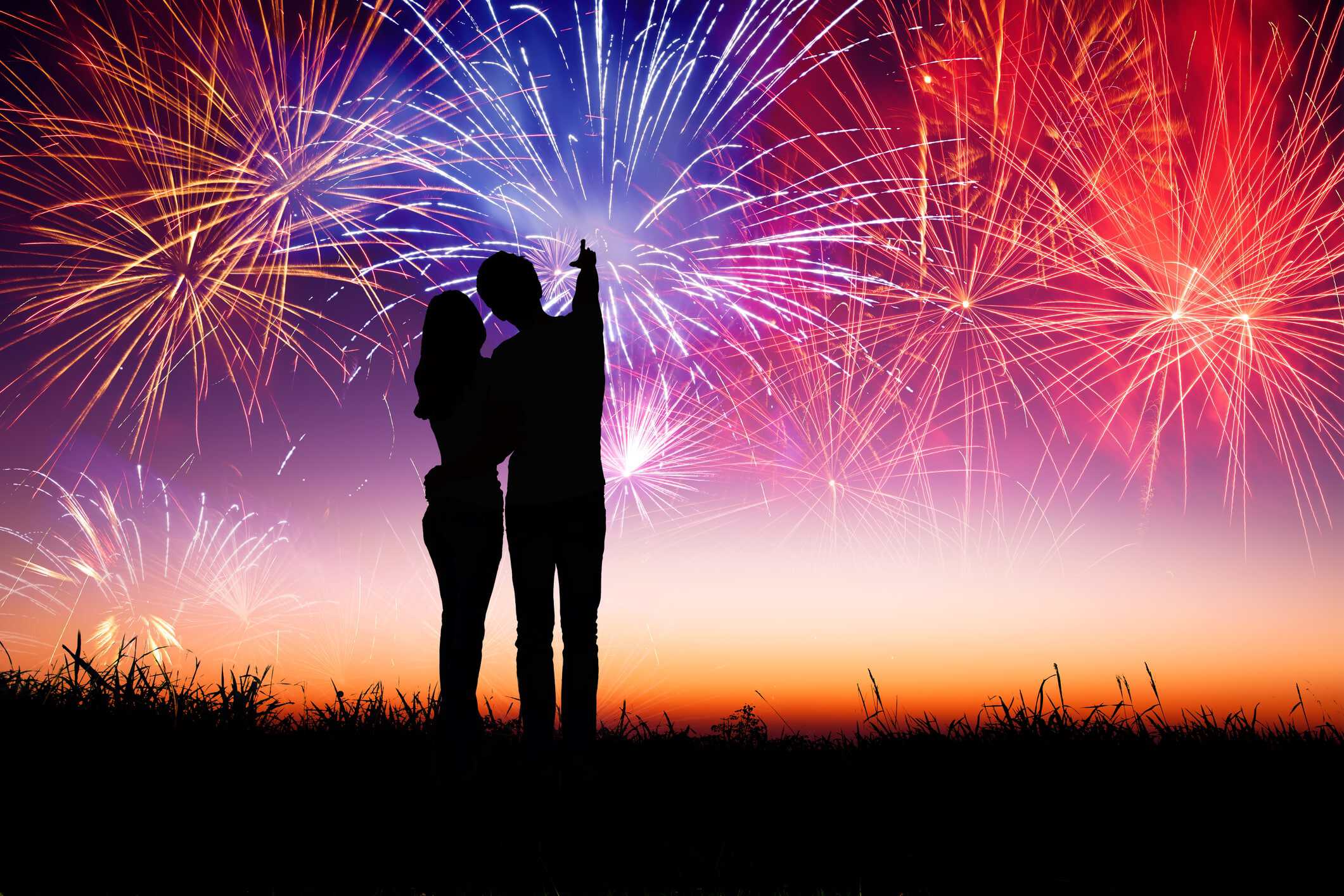 Silhouette of a snuggly couple who understood dating truths watching fireworks on New Years.