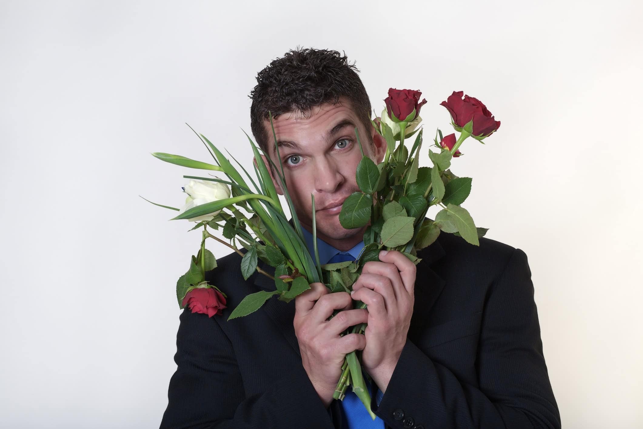 Man who is holding a bouquet of broken roses and finding true love difficult.