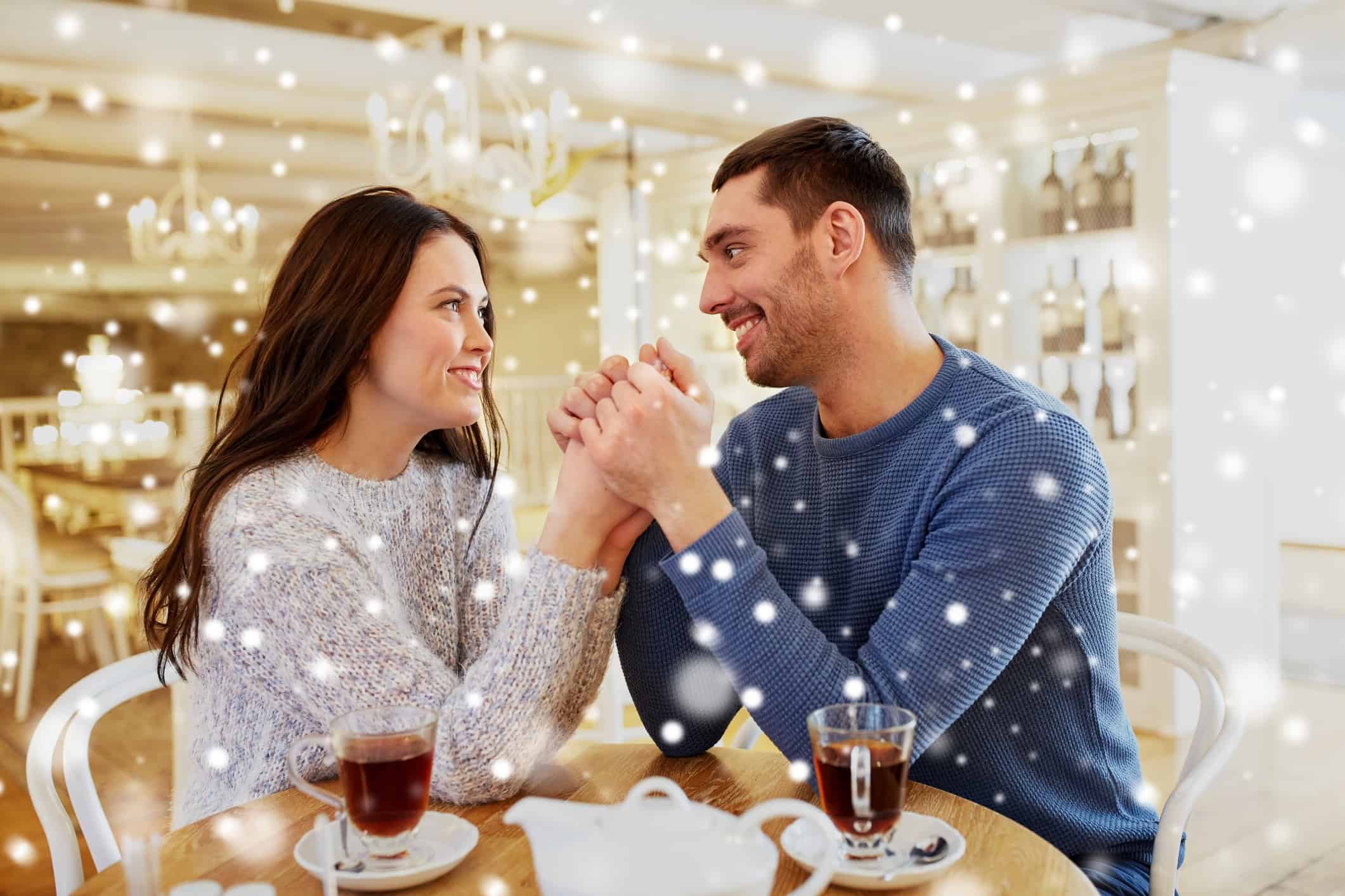 Man and woman holding hands and gazing adoringly into each other's eyes.