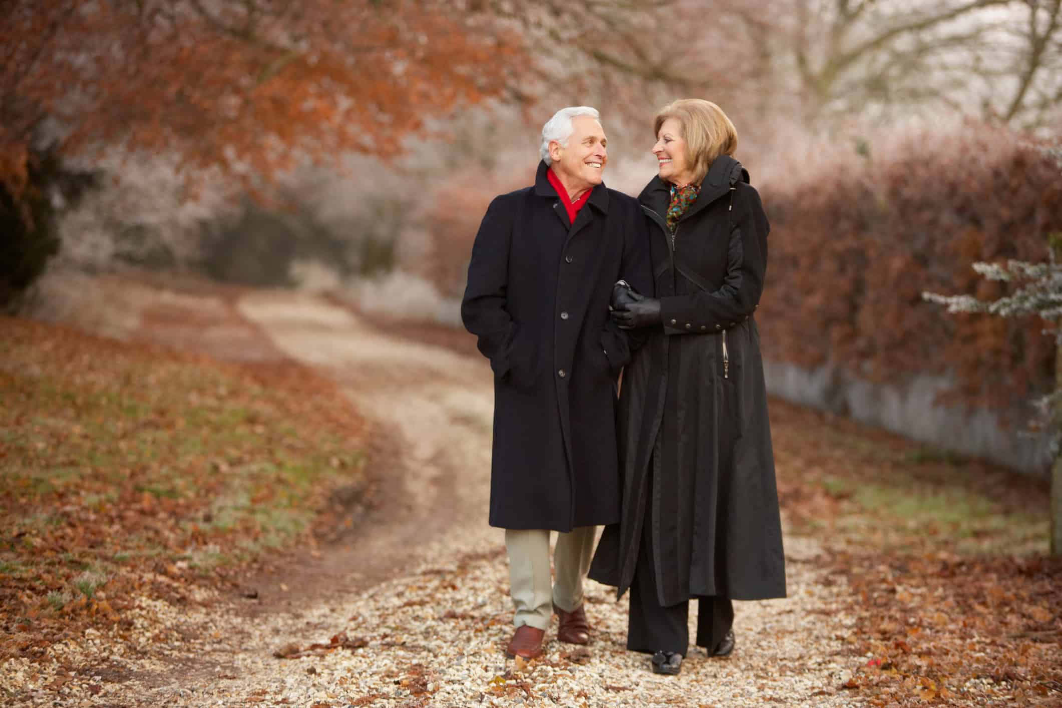Happy mature couple walking outside on a cold day and basking in their love to last a lifetime.
