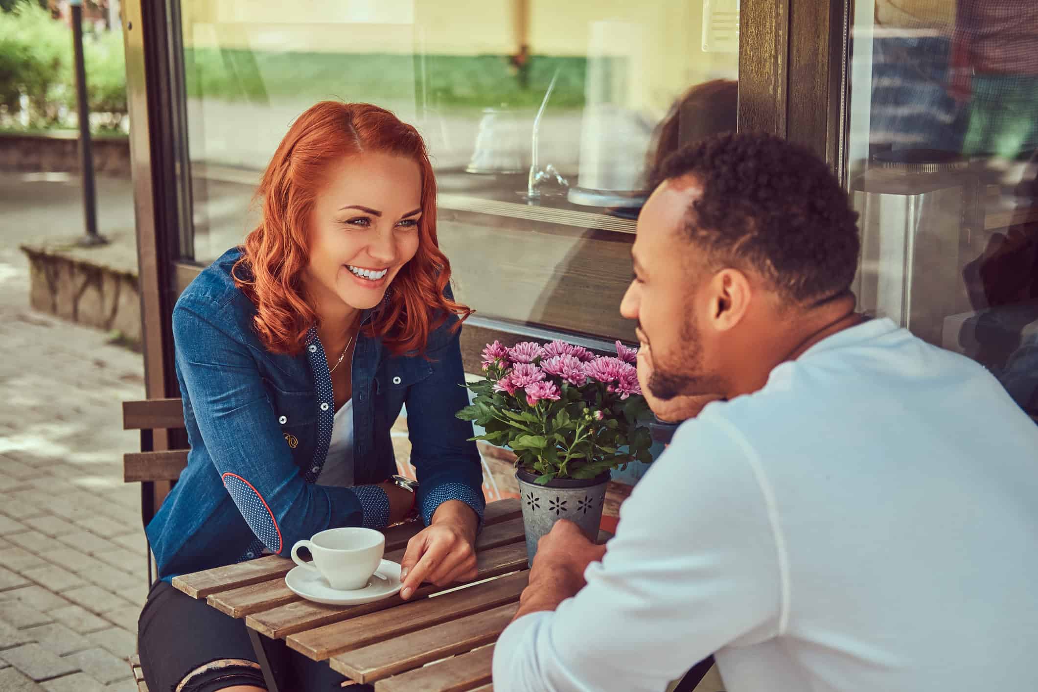 Couple chatting over coffee about relationship-building questions.