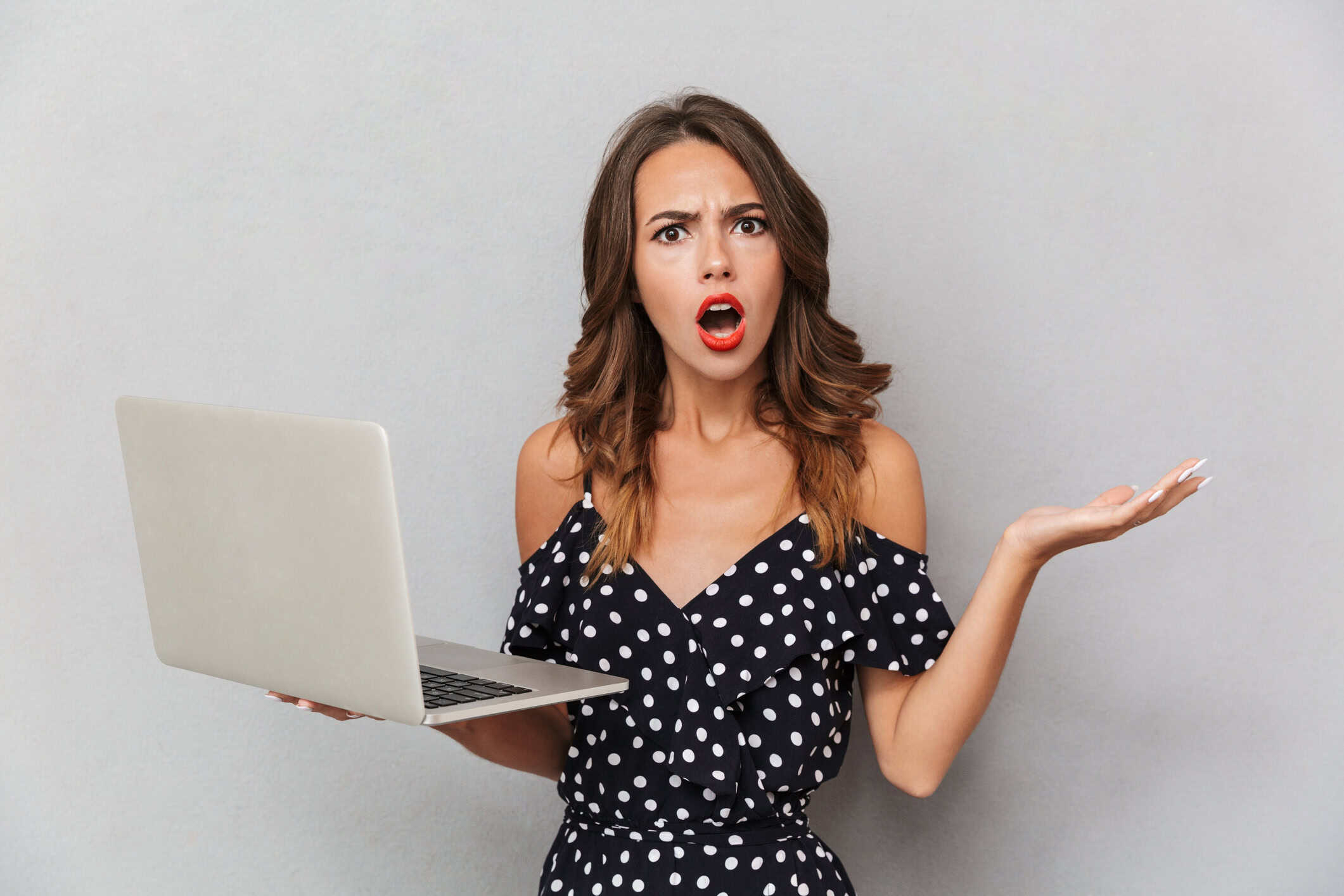 Woman holding a laptop wondering how to find love online.
