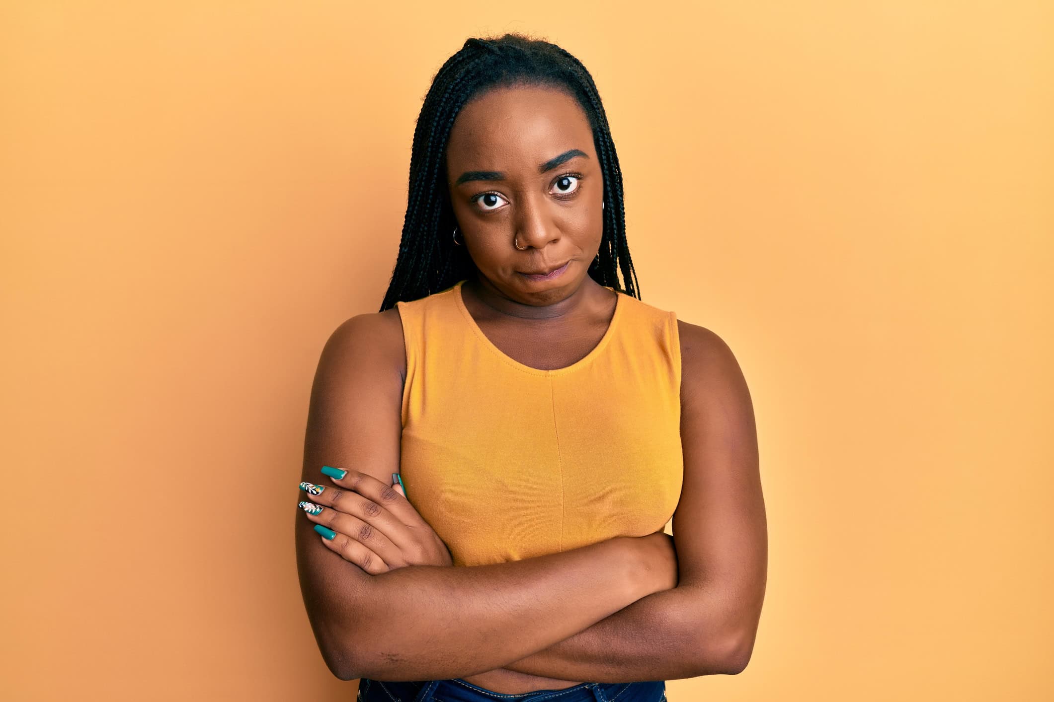 Woman with her arms crossed looking frustrated because she believes online dating doesn't work for her.